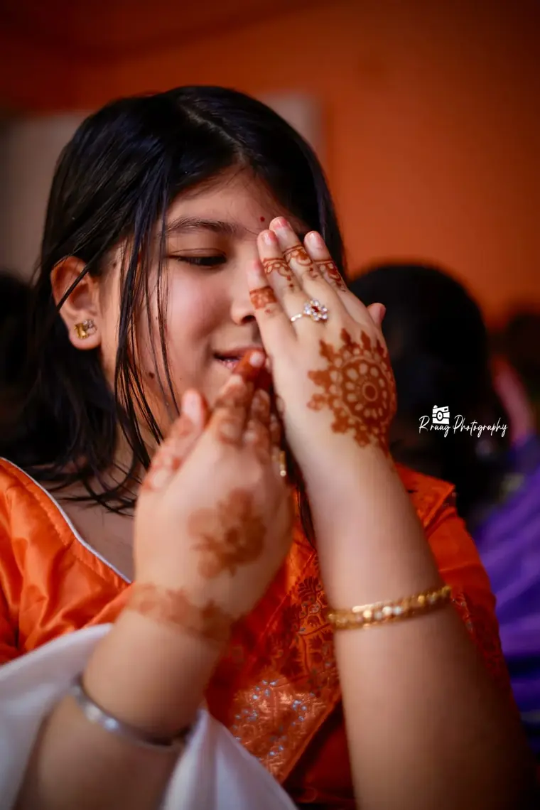 Girl hiding behind her fresh mehendi