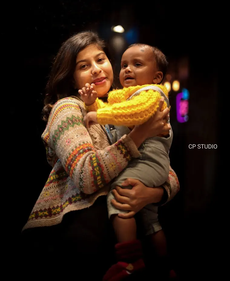 Sister holding her baby brother in the evening
