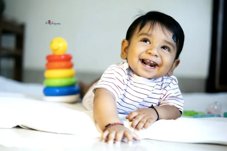 Baby smiling on a white bed