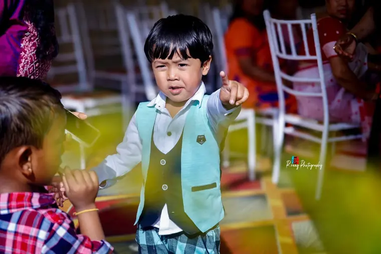 Kid pointing straight at the camera mid-party