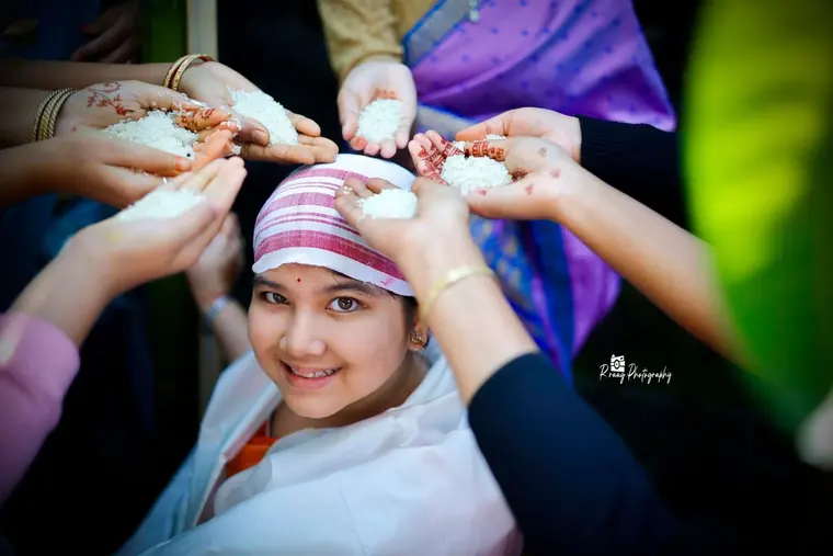 Many hands blessing her with rice