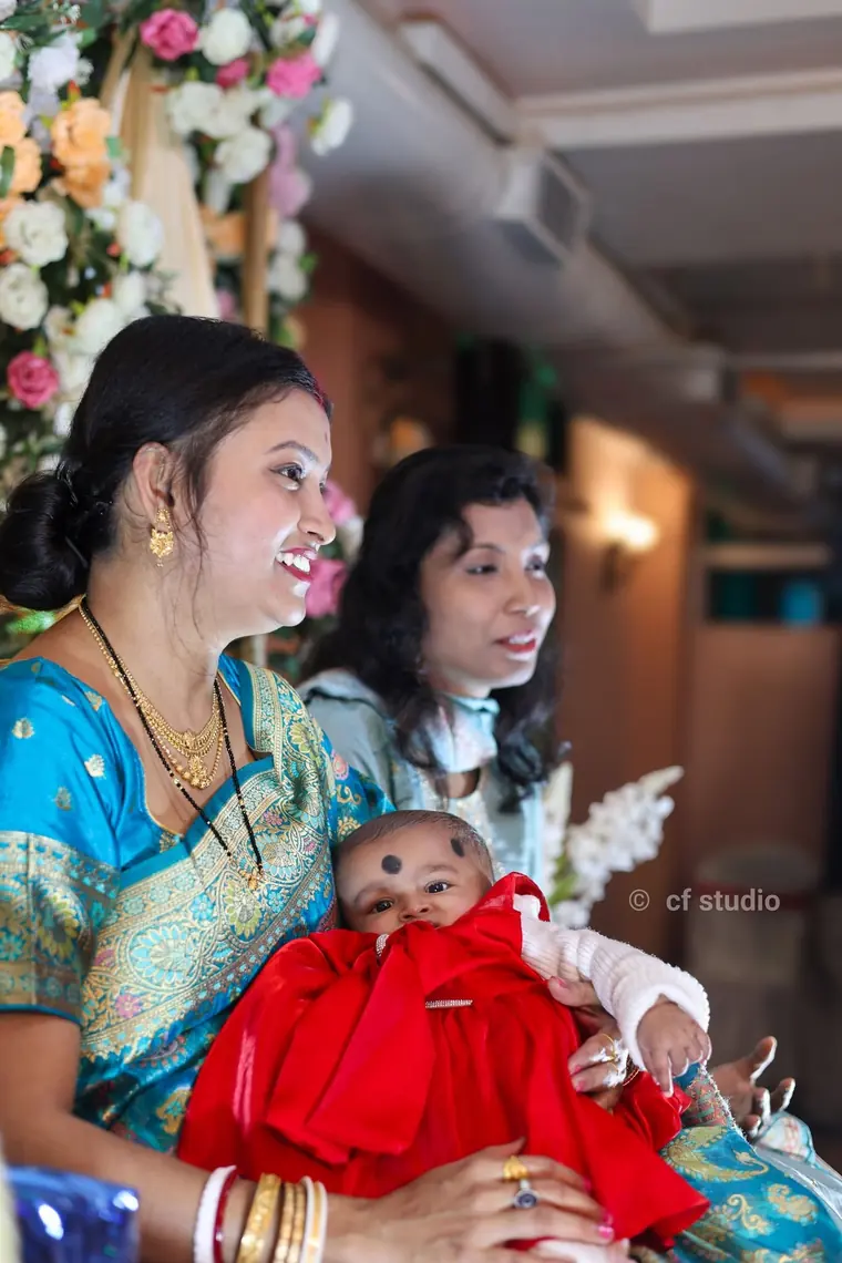 The family gathered around the baby in red
