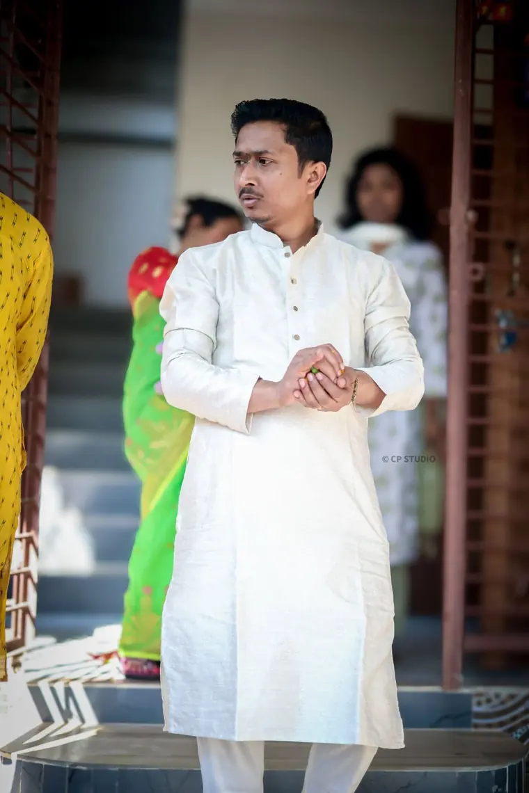 Groom in white kurta on the steps
