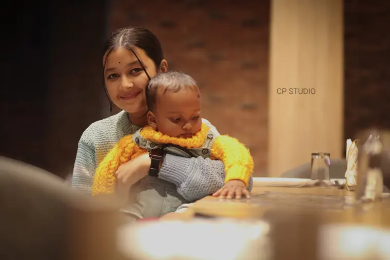 Elder sister with the baby on her shoulder